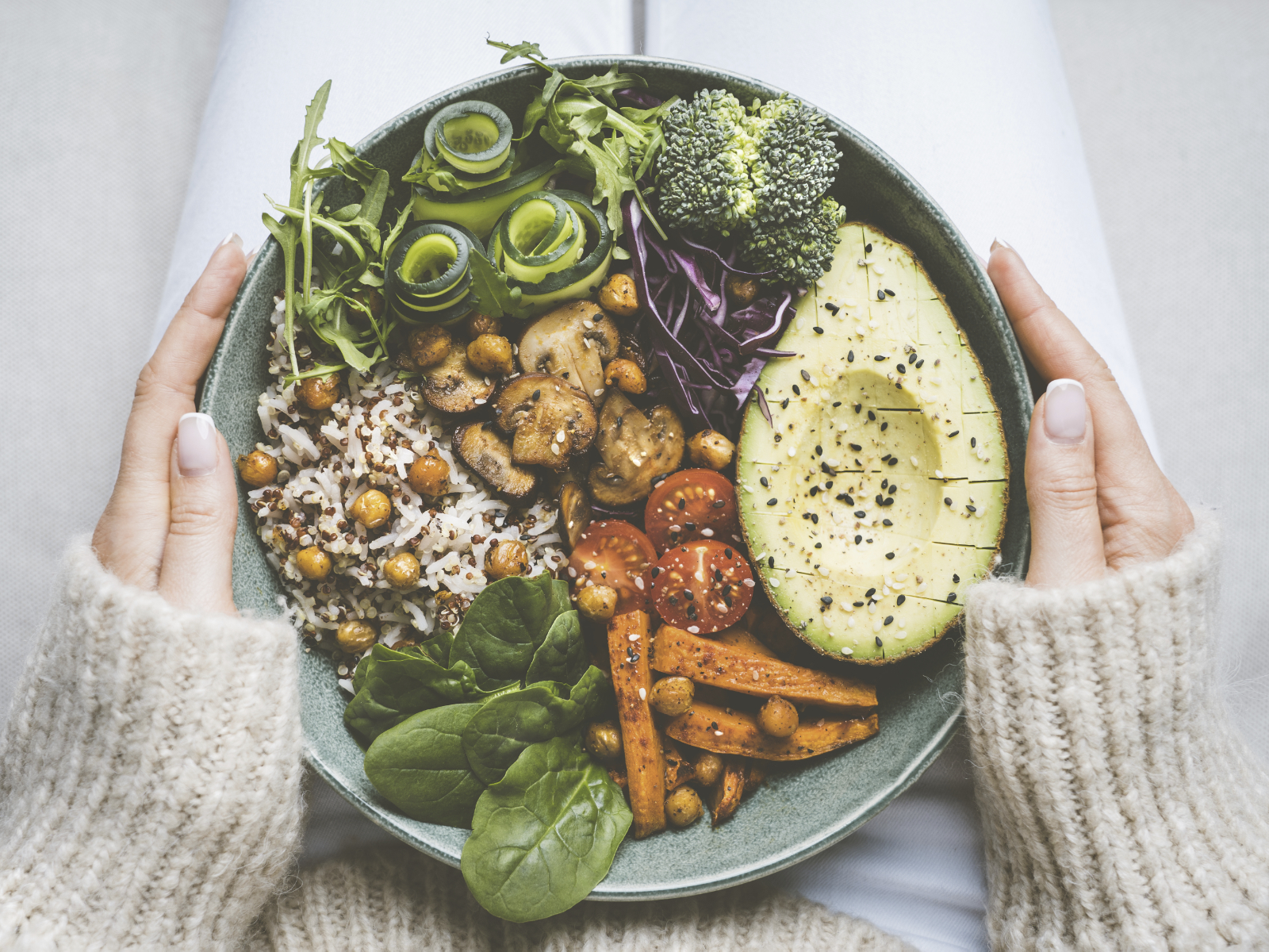 woman holding healthy bowl of plant-based foods