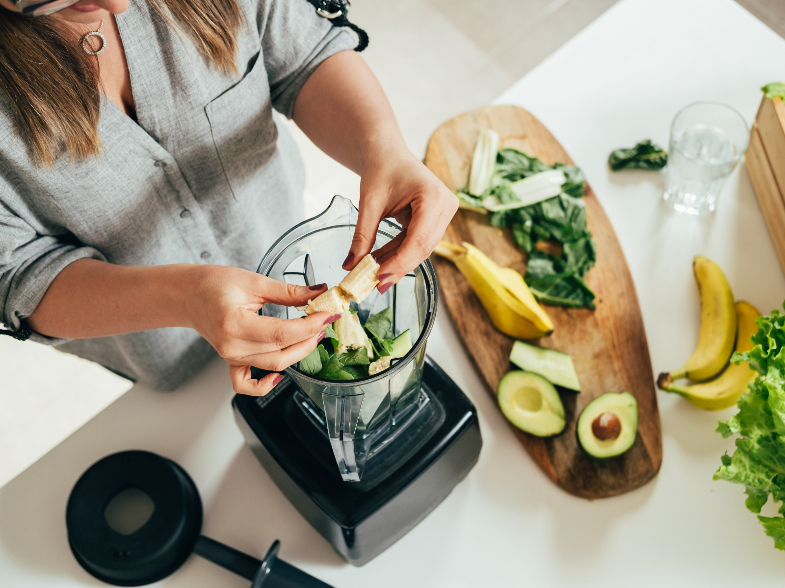 woman making smoothie with avocado and banana